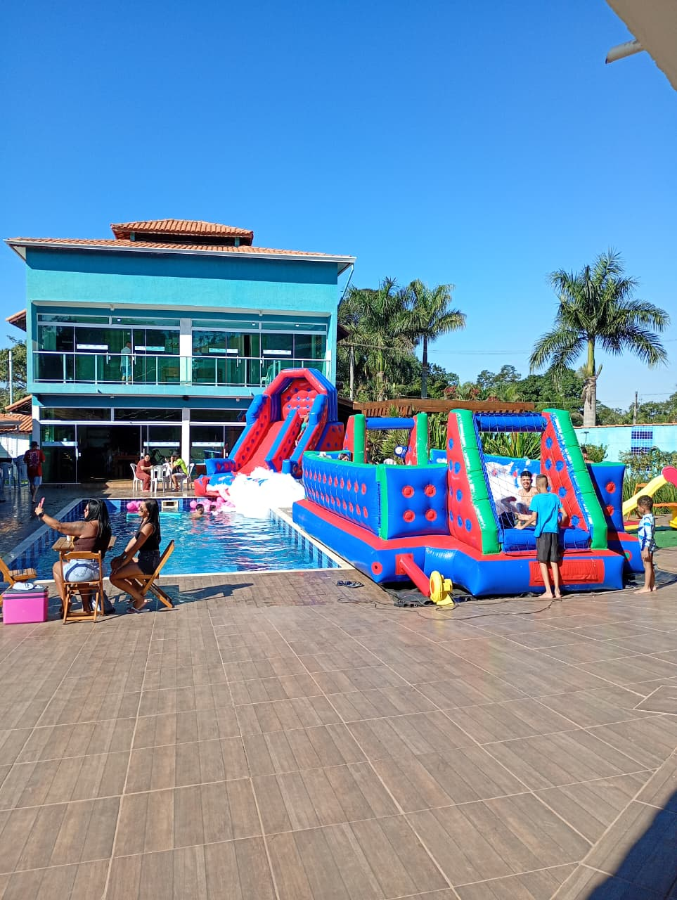 Festa ao ar livre da JD Kids com futebol de sabão inflável, escorrega e piscina