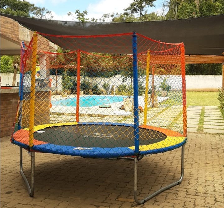 Cama elástica da JD Kids com rede de proteção e bordas coloridas